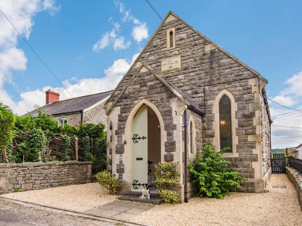 een kleine stenen kerk met een witte deur bij 4 Bed in Bath 89616 in Mells