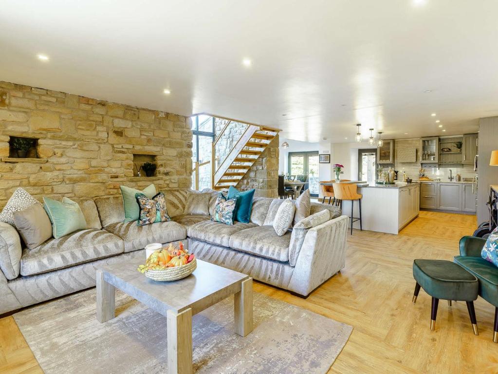 a living room with a couch and a stone wall at 3 Bed in Skipton 89582 in Colne