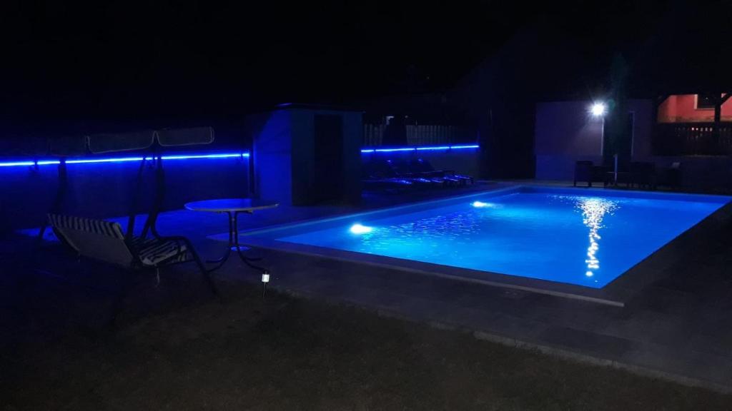 una piscina por la noche con luces azules en Villa Ruzmarin, en Zolaći