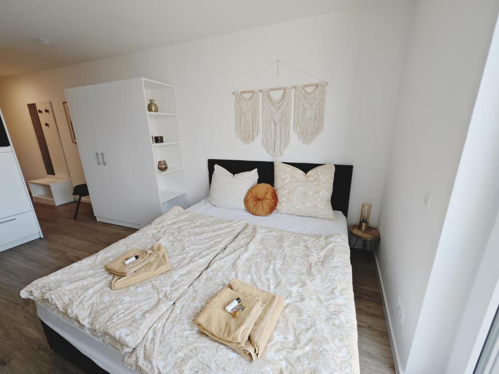 a bedroom with a large bed with two towels on it at CASA GOLD-Zentral-Outlet-Aufzug-Stylisch-Unique in Metzingen