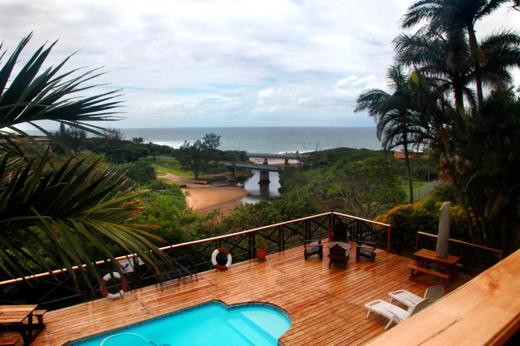 balcone con piscina e vista sull'oceano di Mzimayi River Lodge a Hibberdene