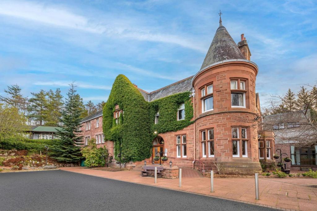 a large brick building with ivy growing on it at Hilton Grand Vacations Club Craigendarroch Suites Scotland in Ballater
