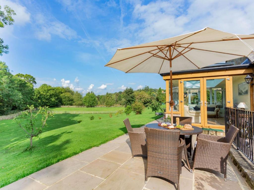 a patio with a table and chairs and an umbrella at 2 Bed in Pateley Bridge 89622 in Summer Bridge