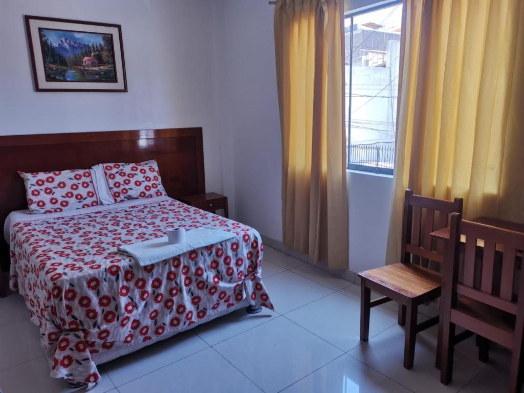 1 dormitorio con 1 cama, 1 silla y 1 ventana en Hotel ESPLENDOR, en Chiclayo