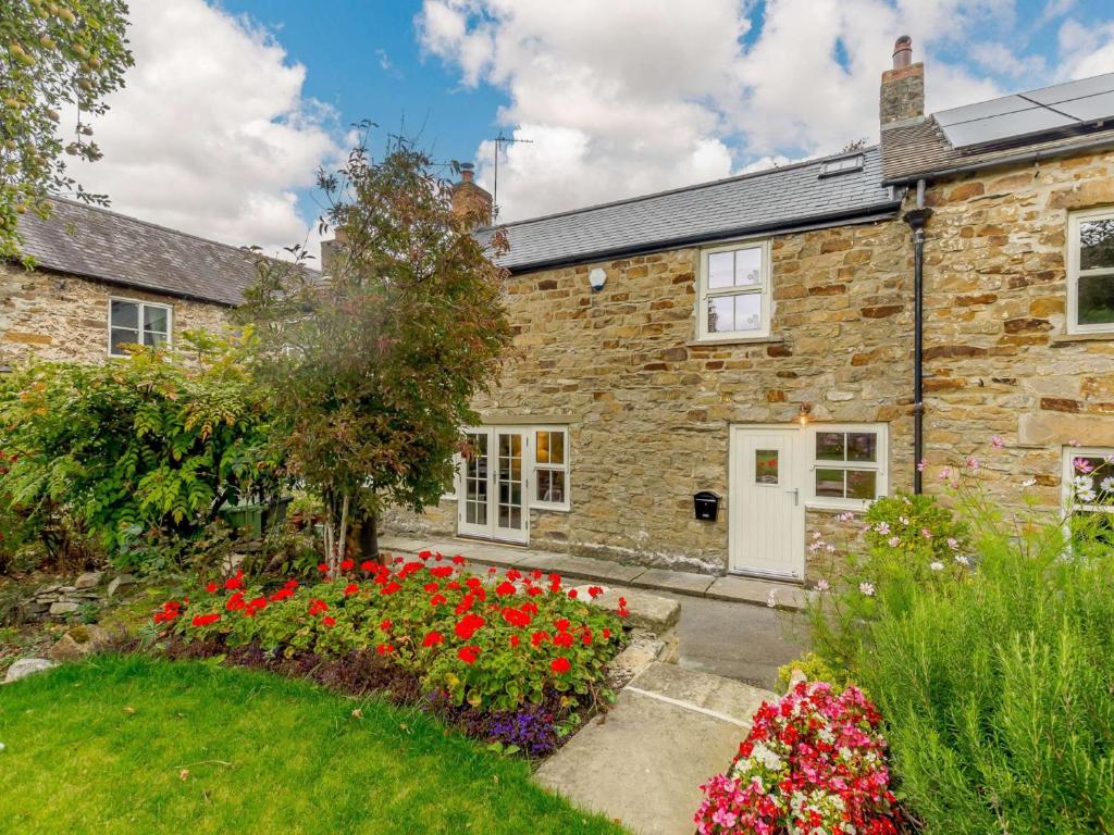 a stone house with a garden in front of it at 3 Bed in Leyburn 89746 in Spennithorne