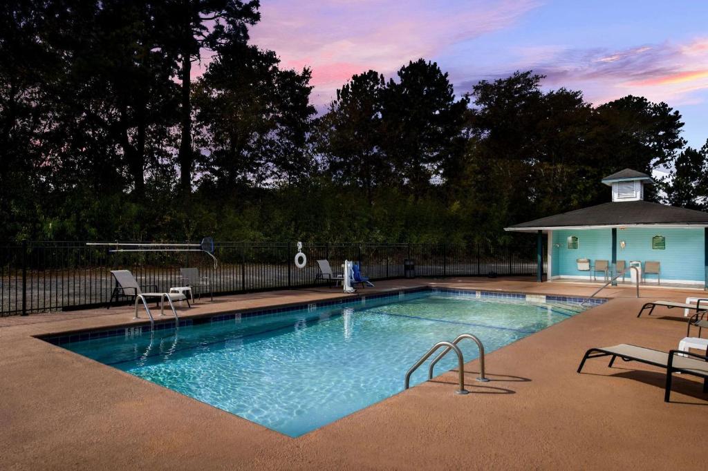 a swimming pool with chairs and a gazebo at Quality Inn & Suites Vidalia in Vidalia