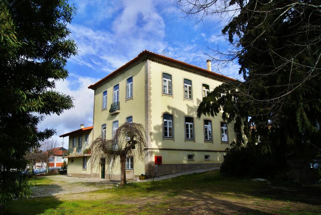 um grande edifício branco com uma árvore em frente em Hotel Rural Villa Julia em Vila Flor