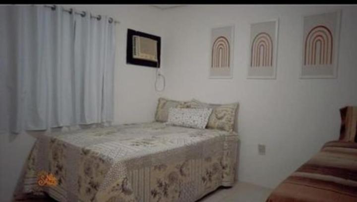 a bedroom with a bed in a white room at Pousada Pé na Areia in São José da Coroa Grande
