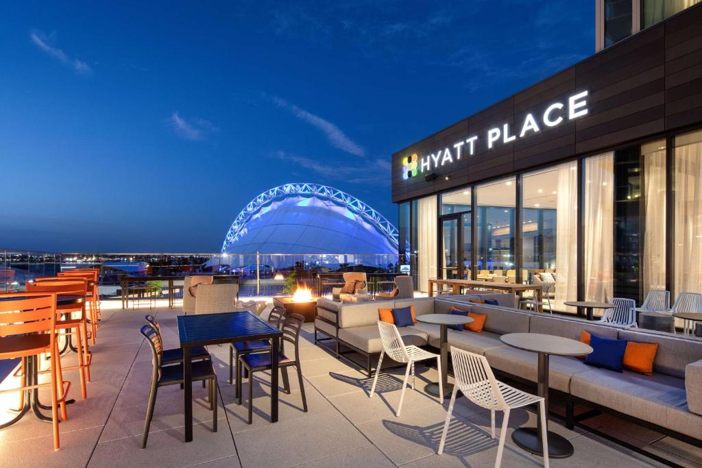 un restaurant avec des tables et des chaises sur le toit d'un bâtiment dans l'établissement Hyatt Place Boston/Seaport District, à Boston