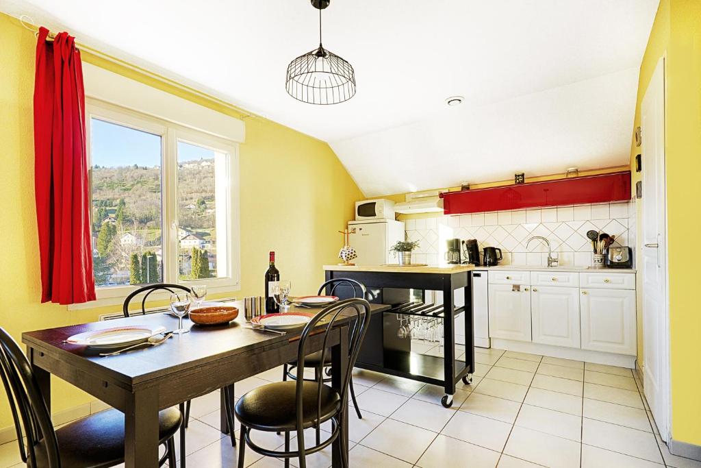 une cuisine avec une table et des chaises ainsi qu'une salle à manger dans l'établissement Comme Chez Soi - Vue montagne et garage privé, à La Bresse