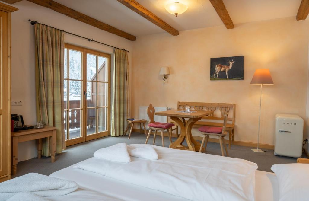 Schlafzimmer mit einem Bett, einem Tisch und Stühlen in der Unterkunft Gasthof Auwirt in Aurach bei Kitzbuhel