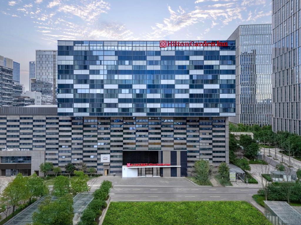 um grande edifício com uma placa em cima em Hilton Garden Inn Nanjing Hexi Olympic Sports Center em Nanquim