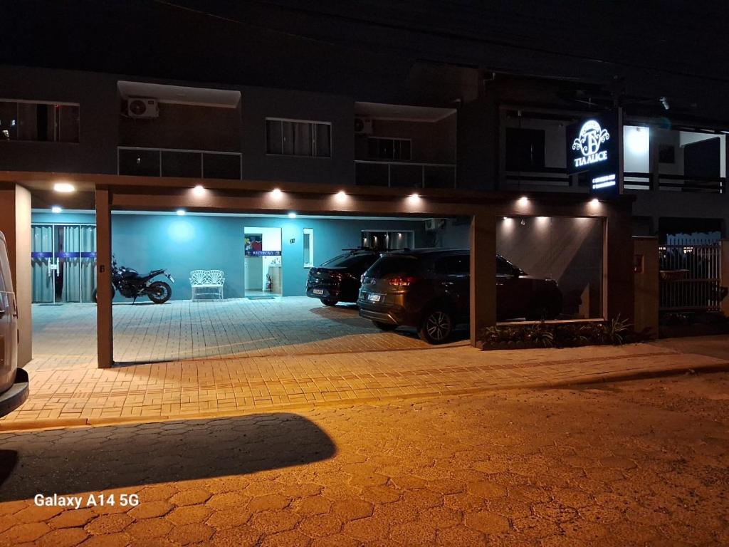 a garage with cars parked in it at night at Pousada Tia Alice in Penha