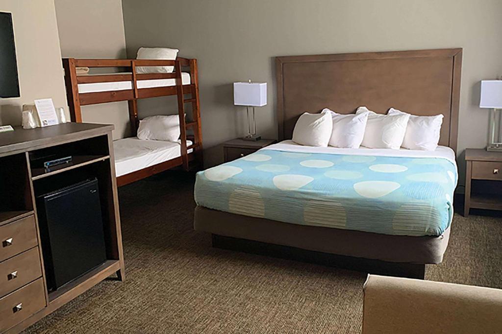 a hotel room with a bed and bunk beds at Baymont by Wyndham Monte Vista in Monte Vista