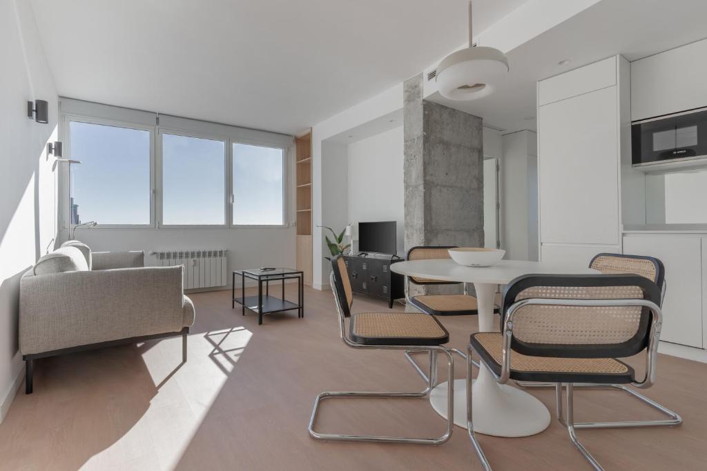 ein Wohnzimmer mit einem Tisch und Stühlen in der Unterkunft Bright with views -2Bd 1Bth- Bernabeu in Madrid