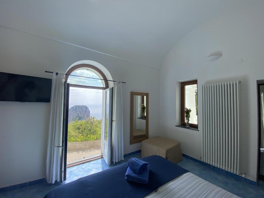 a bedroom with a bed and a large window at Monacone vista mare in Capri