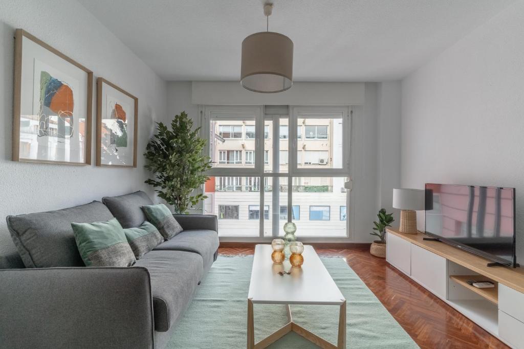 a living room with a couch and a tv at Brigth Stylish studio - Gran Vía in Madrid