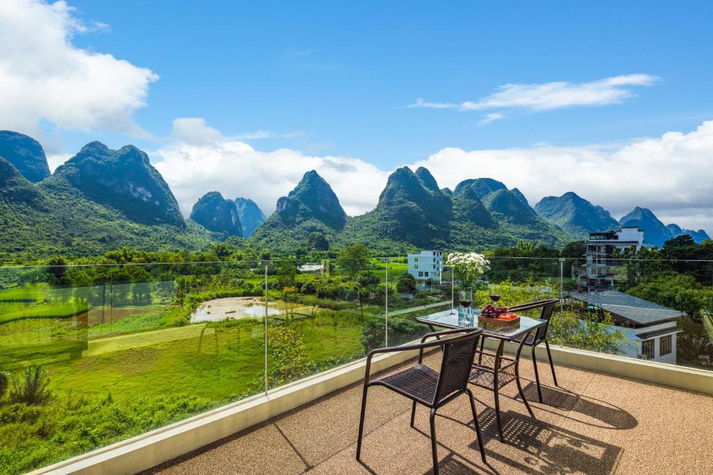 a balcony with a view of the mountains at Dreamland Inn in Yangshuo