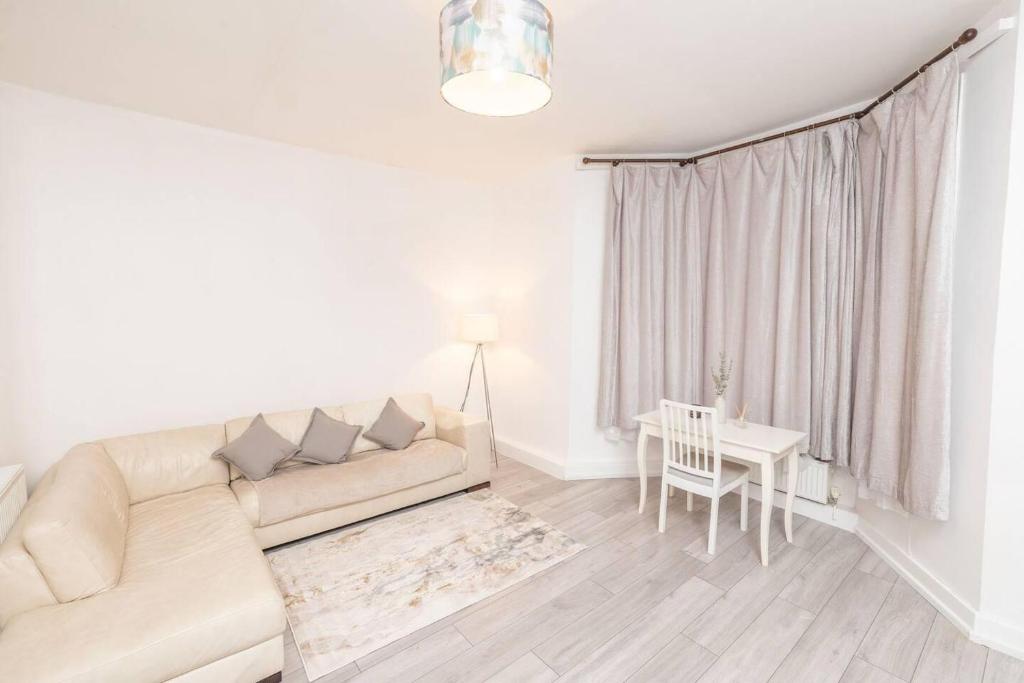 - un salon blanc avec un canapé et une table dans l'établissement Beautiful 2-Bed Haven In Chelsea, à Londres