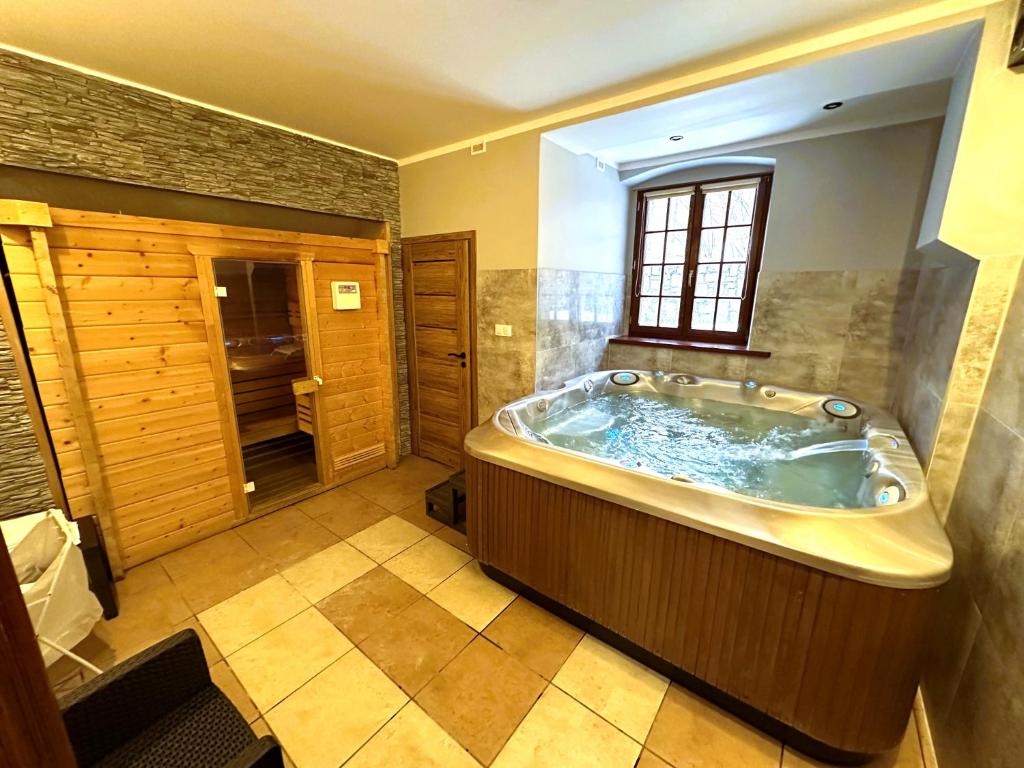 een groot bad in een badkamer met een raam bij Apollo & SPA Karpacz in Karpacz