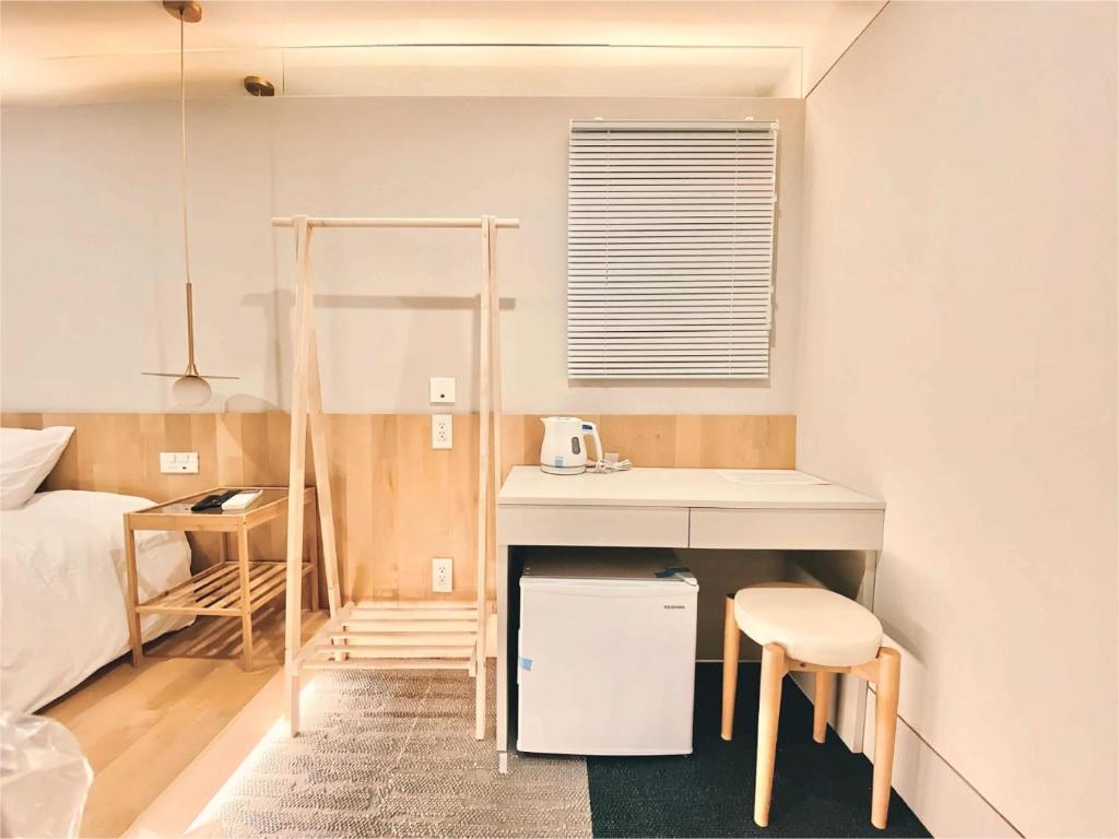 Habitación pequeña con cama, mesa y escritorio. en 东京上野超级中心 设计师房间Ycoe 上野公园3分钟 车站1分钟 超级繁华 免费wifi 戴森吹风, en Tokio