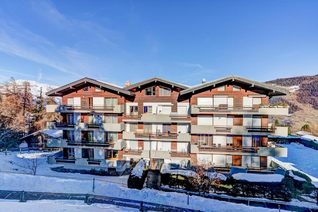 an apartment building with snow on the ground at Appartement Nevada 104 Spa in La Tzoumaz