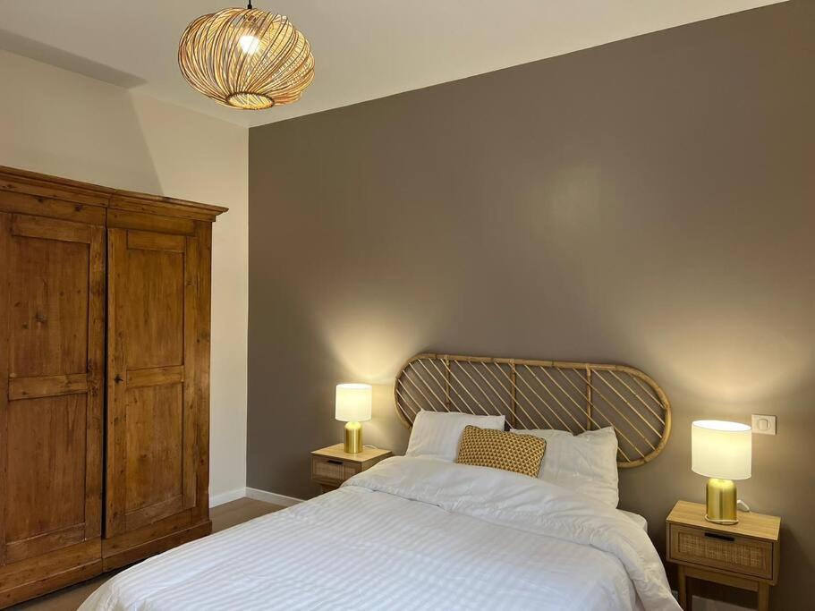 een slaapkamer met een bed met 2 nachtkastjes en 2 lampen bij Grange 8 personnes in Billère