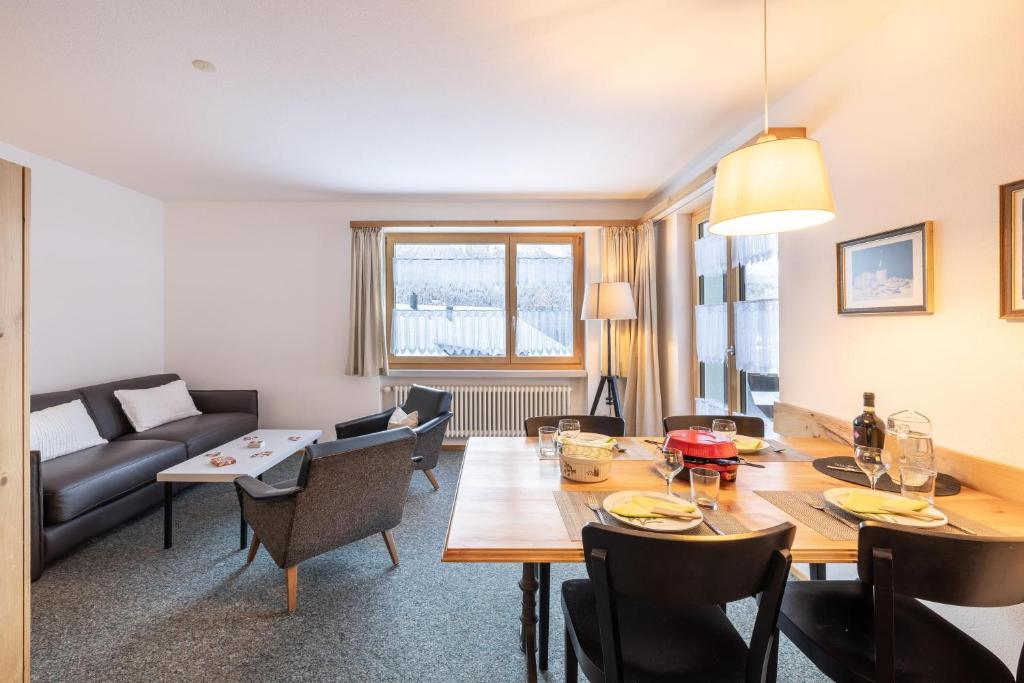 a living room with a dining table and a couch at Chasa Val 2 in Scuol