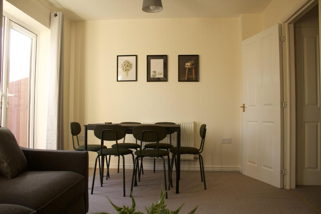 un soggiorno con tavolo e sedie di Spacious 4 bedroom, perfect for contractors, families, private parking a Wootton Bassett