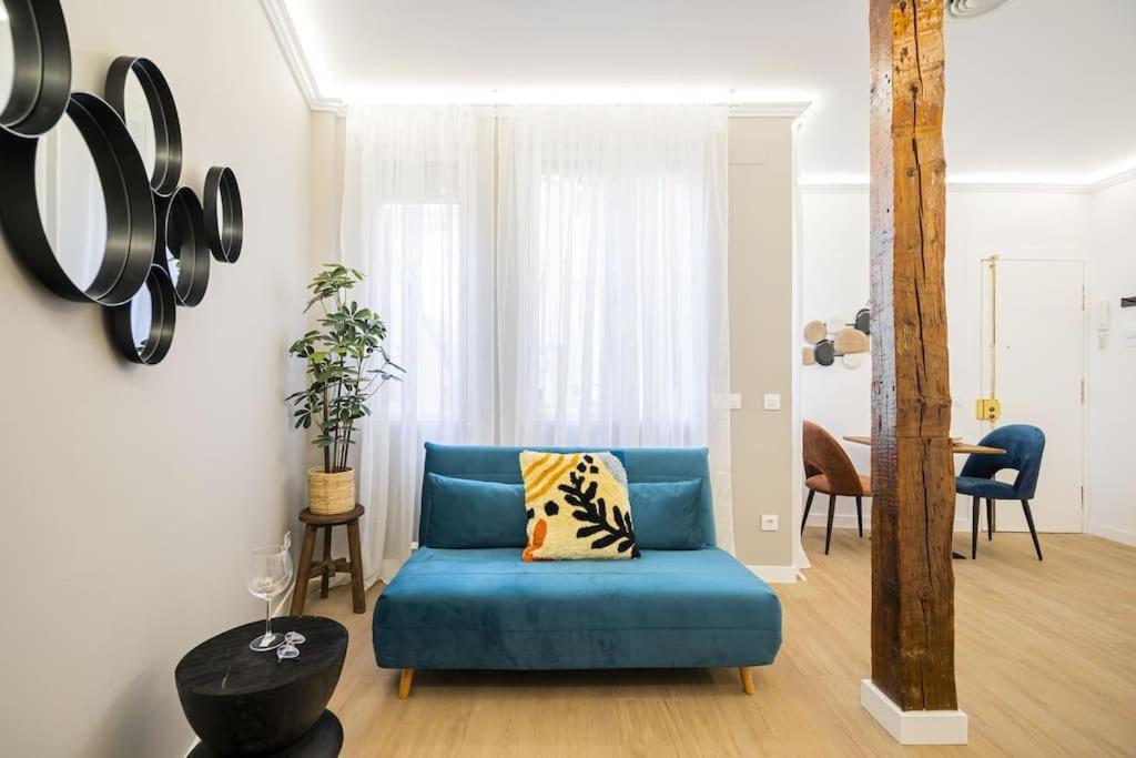 a living room with a blue couch and a table at Plaza Mayor cozy Private apartment with AC in Madrid