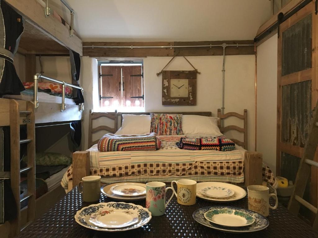 a small room with a bed with plates on a table at Matlock Glamping Rooms in Matlock