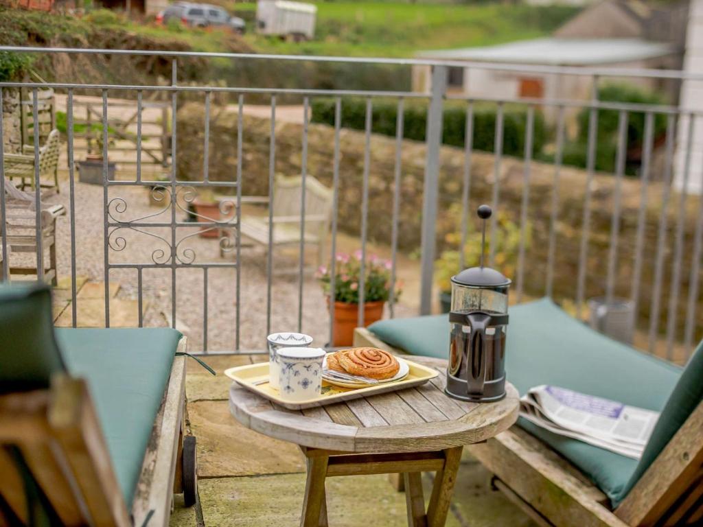 a table with a plate of food on a balcony at 1 Bed in Hope Cove 90026 in Hope Cove