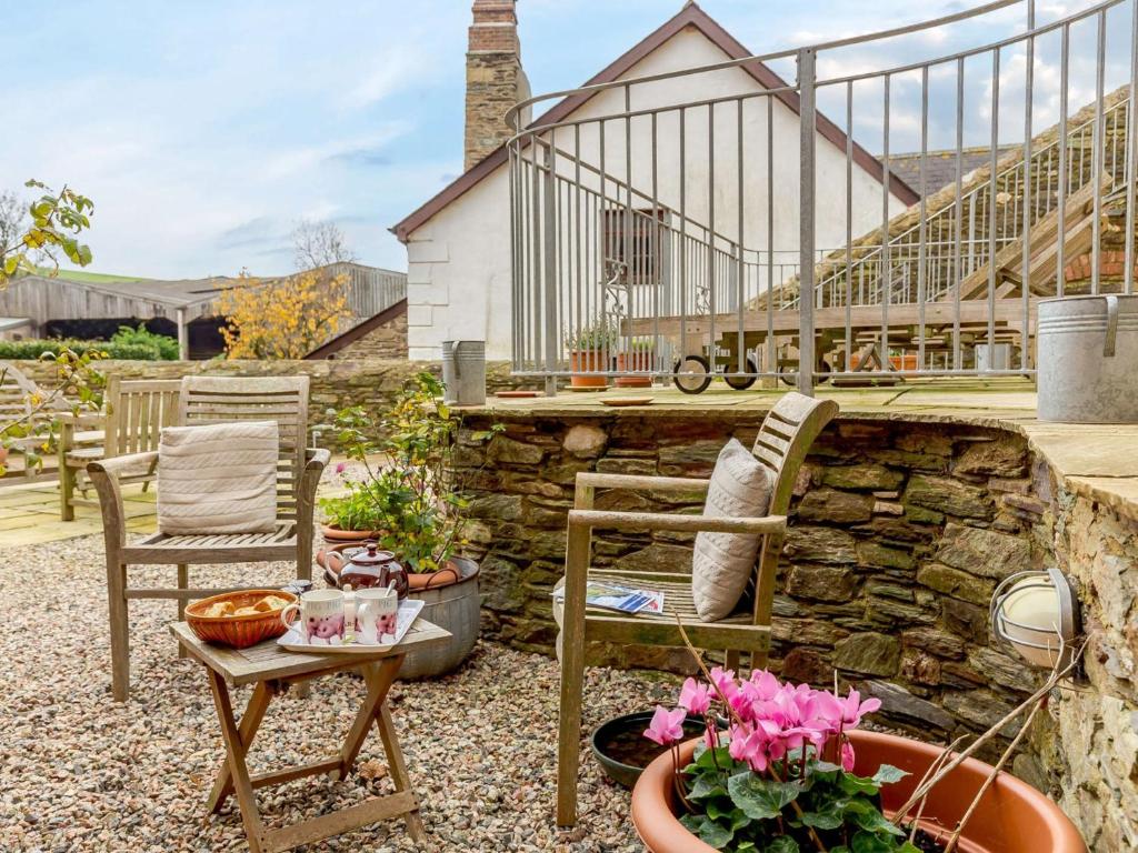 a patio with a table and chairs and plants at 2 Bed in Hope Cove 90025 in Hope-Cove