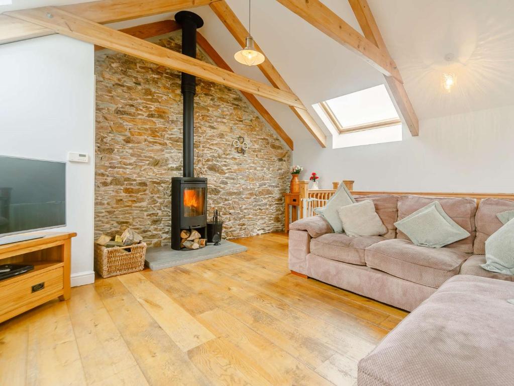 a living room with a couch and a fireplace at 3 Bed in Newquay 89941 in Mawgan Porth