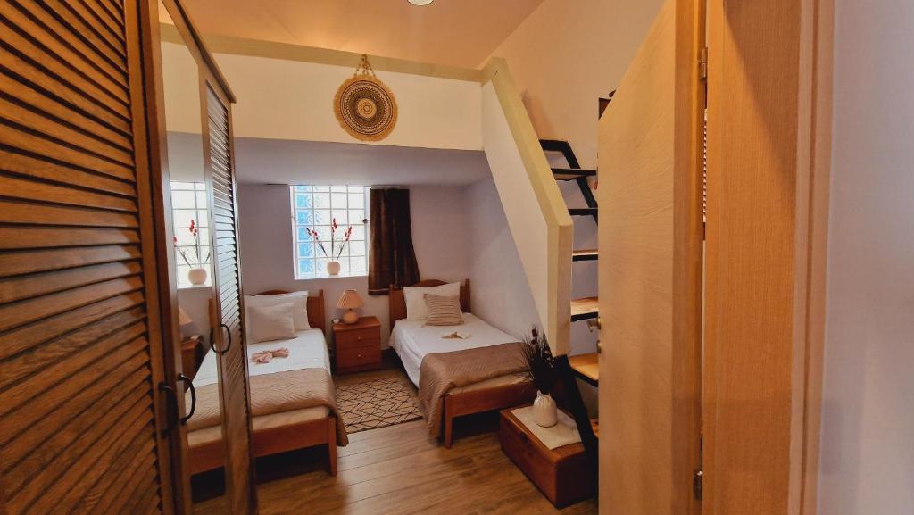mały pokój z łóżkiem i schodami w obiekcie Seva Monolithos house w mieście Monólithos
