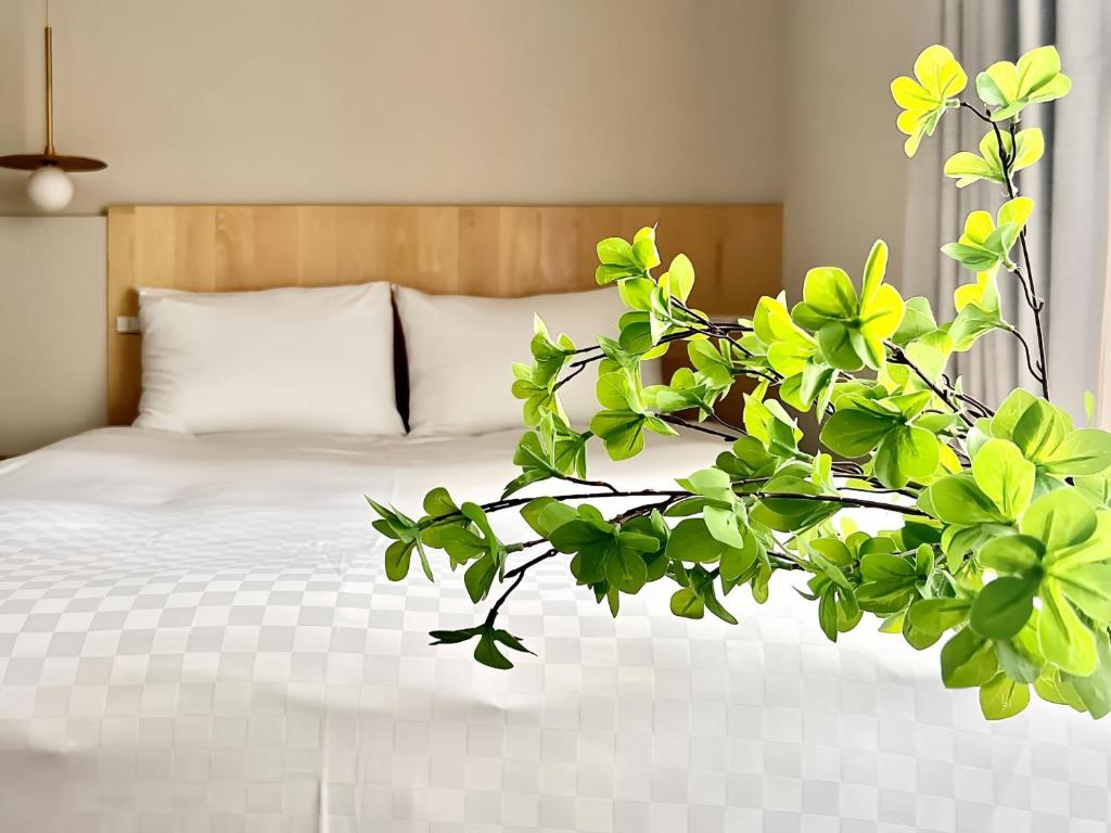 um quarto com uma cama com uma planta verde em 上野超豪华4人间 东京超级中心Ydoa 设计师房间 上野公园3分钟 车站1分钟 超级繁华 免费wifi 戴森吹风 em Tóquio