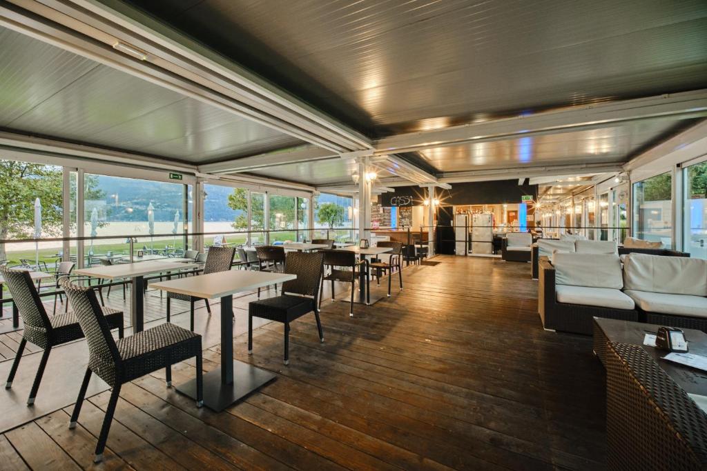 een restaurant met tafels, stoelen en ramen bij Seven Park Hotel Lake Como - Adults Only in Colico