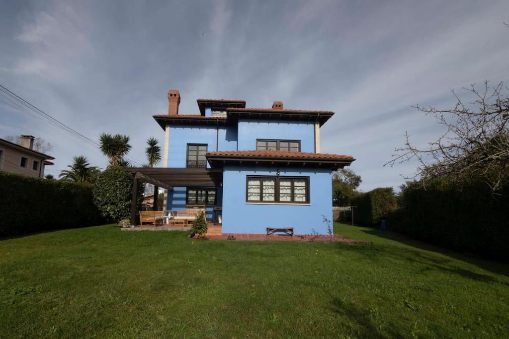 une maison bleue et blanche avec une cour verdoyante dans l'établissement Llanes: Casa Azul de Pancar, à Pancar