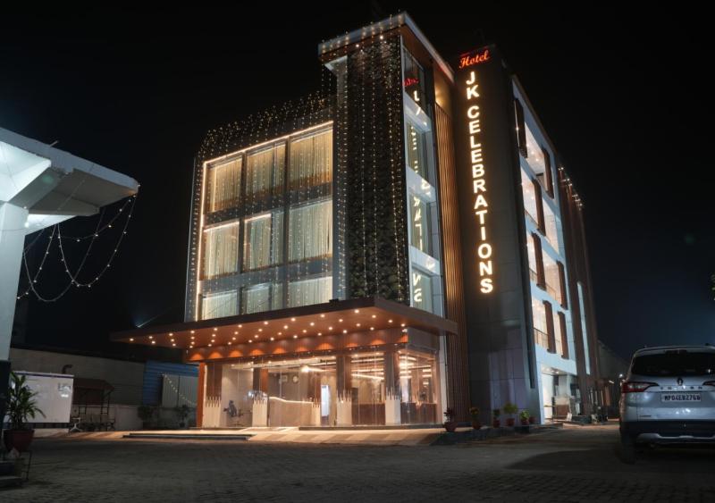 un gran edificio con un cartel en él por la noche en Hotel JK Celebration, en Jabalpur
