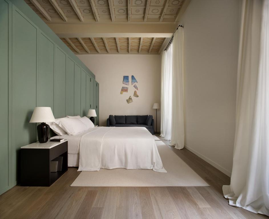 a bedroom with a white bed and a chair at Parisii Bocca di Leone 88 in Rome