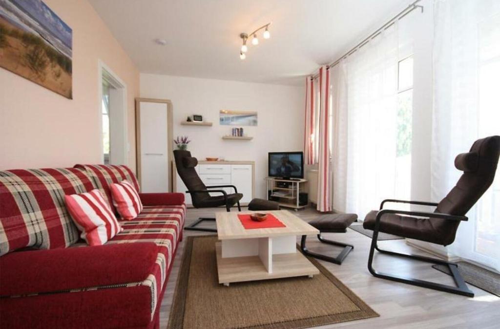 キュールングスボルンにあるStrandschloesschen-Haus-II-WE-18-9723のリビングルーム(赤いソファ、椅子付)