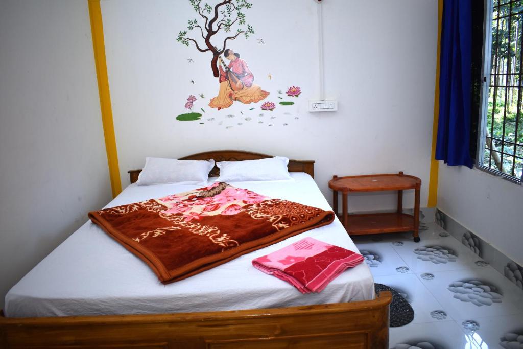 a bedroom with a bed with a blanket on it at Jaldapara Binaychapa homestay in Mādāri Hāt