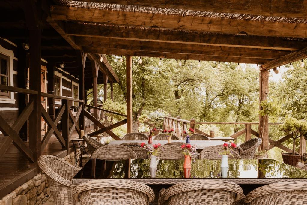 a table with chairs and flowers on a porch at Maciejewka in Zahoczewie