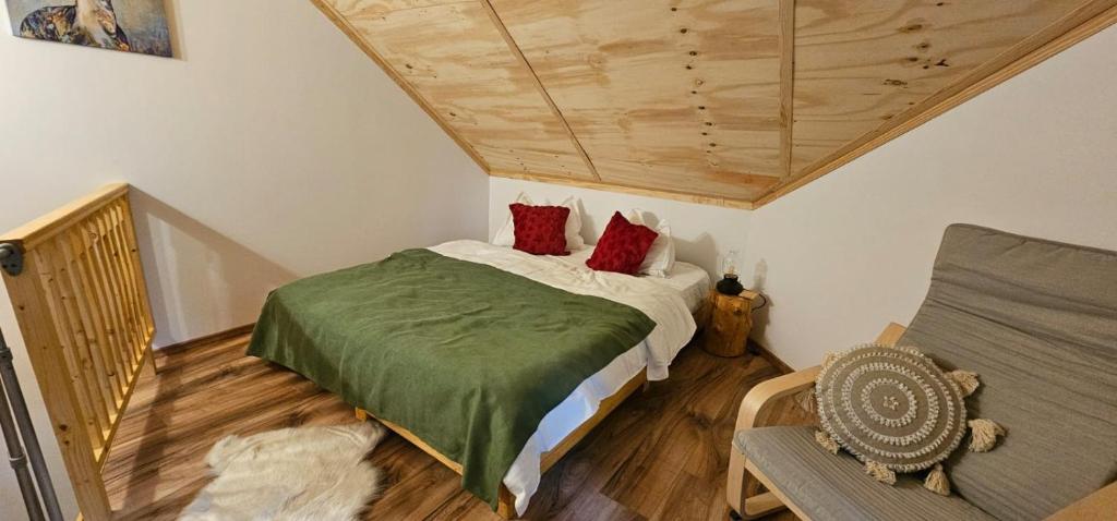 a bedroom with a bed with red pillows on it at Chalet Hay Huy in Buşteni