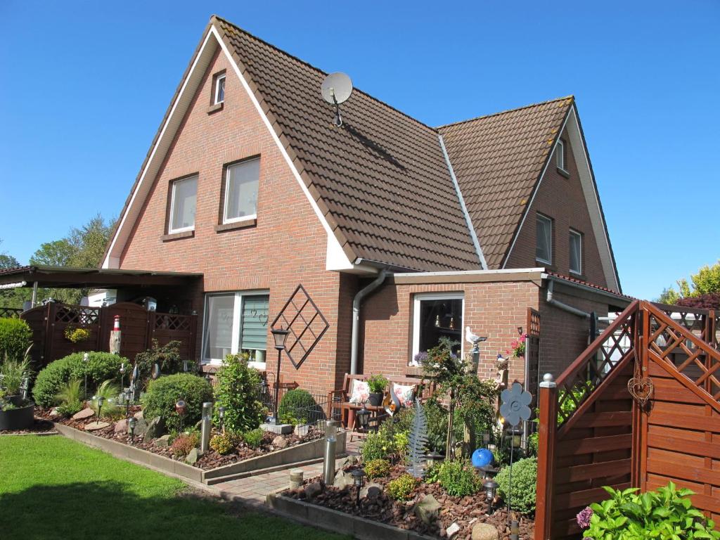 a house with a garden in front of it at Ferienwohnung ERNA HORS110 in Wangerland