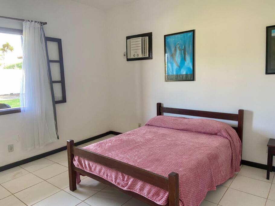 une chambre avec un lit avec une couverture rose dans l'établissement Casa Búzios pé na areia, à Búzios