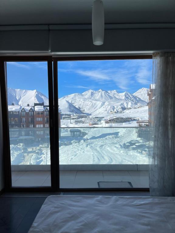 a view of a snowy mountain from a window at Happy Holidays Apartments in New Gudauri in Gudauri