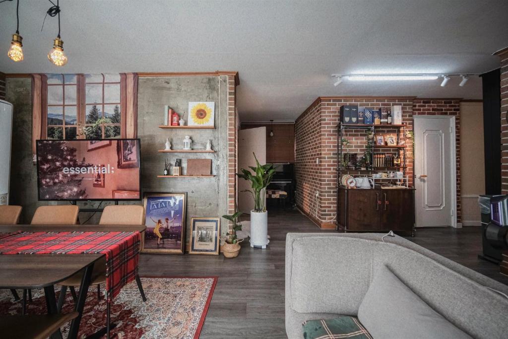 a living room with a couch and a brick wall at Near Hongdae CozyBrickhaus in Seoul