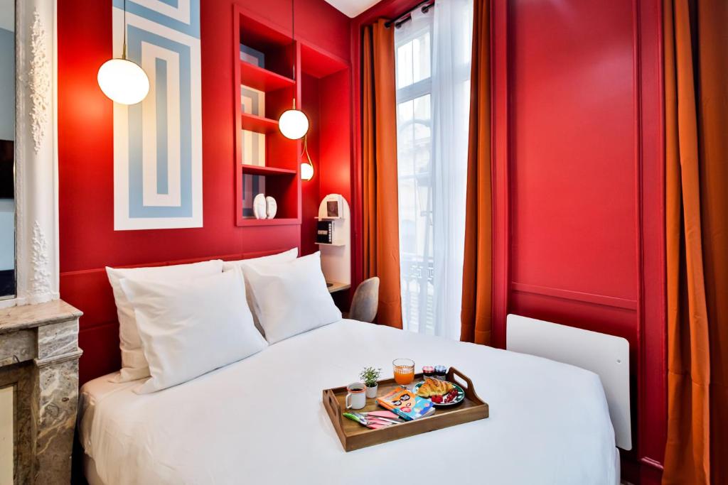 - une chambre avec un lit blanc et des murs rouges dans l'établissement Apartments WS Louvre - Saint-Roch, à Paris
