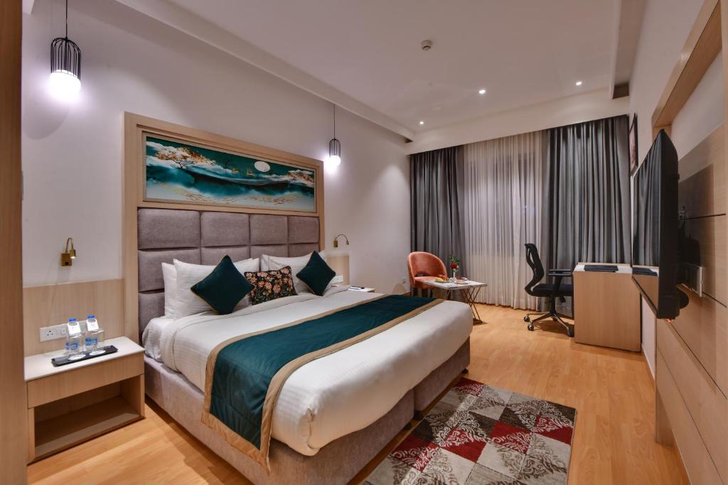 Habitación de hotel con cama grande y TV en Quality Inn Elite, Amritsar en Amritsar